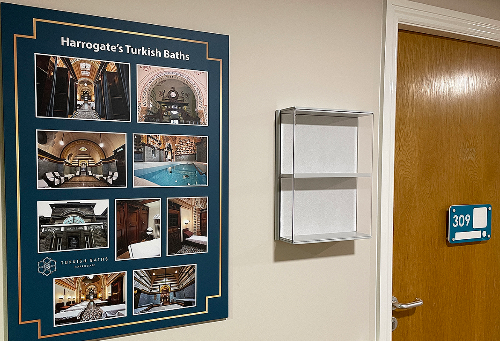 Dementia care home corridor wall displaying locally themed artwork, a personal memory box and dementia friendly personalised bedroom sign on the residents door.