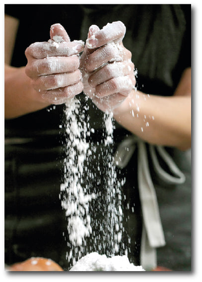 Dementia-friendly reminiscence image of a baker rubbing flour and fat together by hand